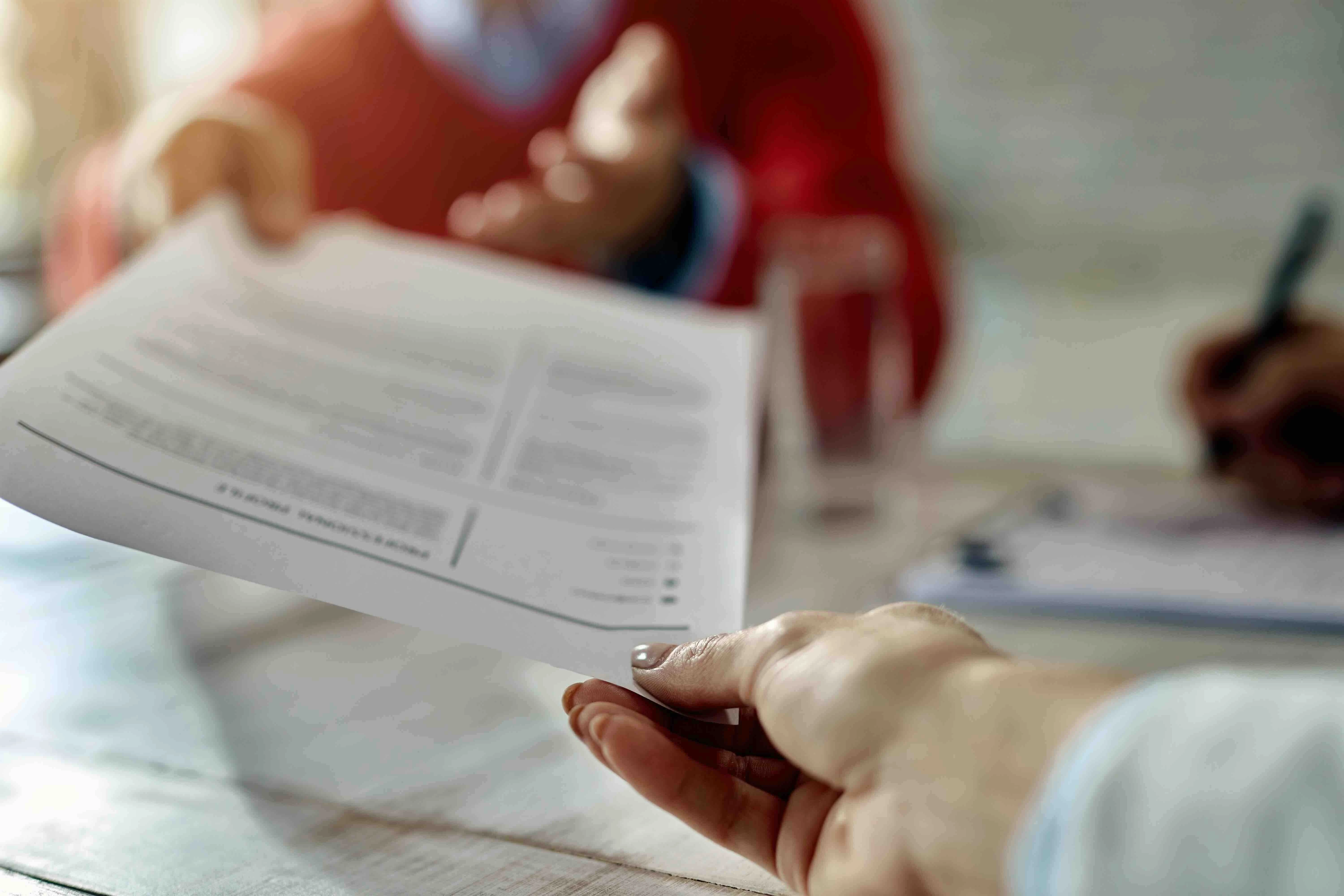 gros-plan-du-demandeur-d-emploi-donnant-son-cv-lors-d-un-entretien-d-embauche-au-bureau